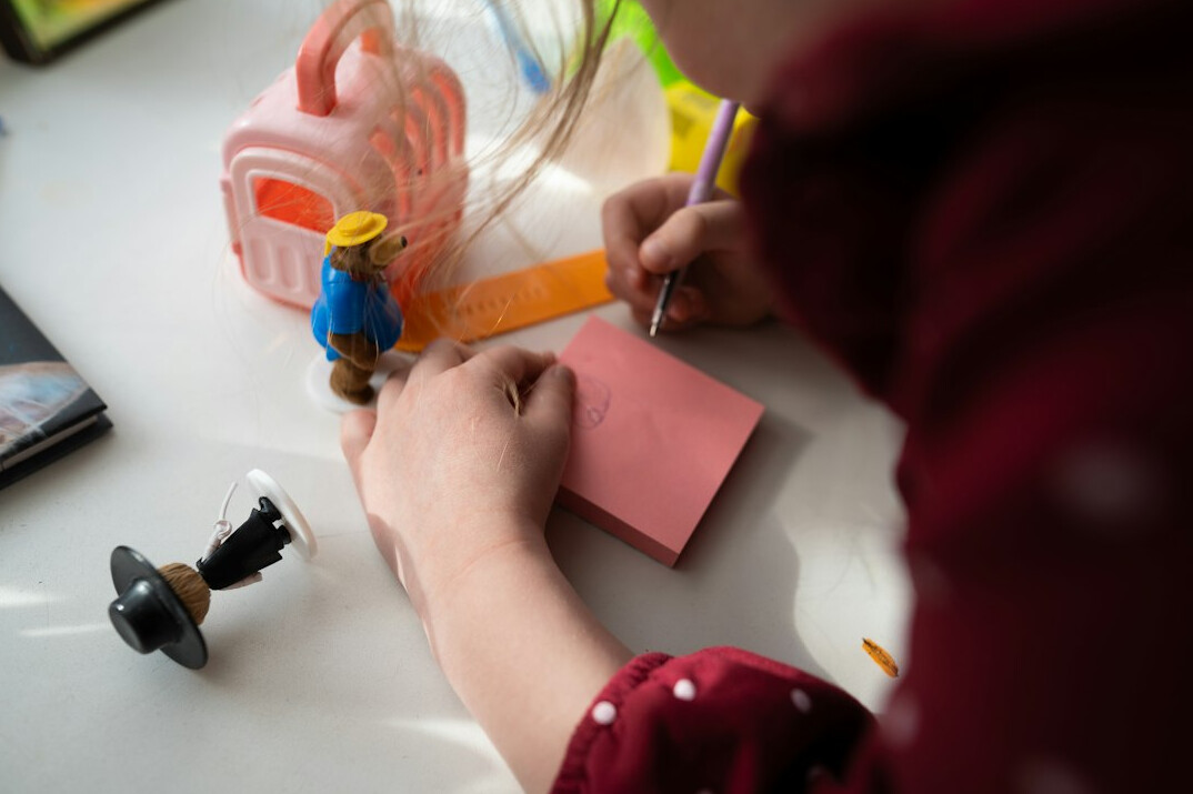 Hands writing notes on documents with a pen at a desk